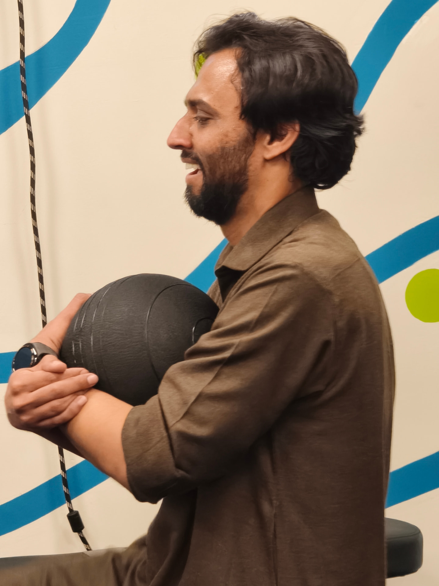 A Karavan member holding a medicine ball at chest height during a supervised training session
