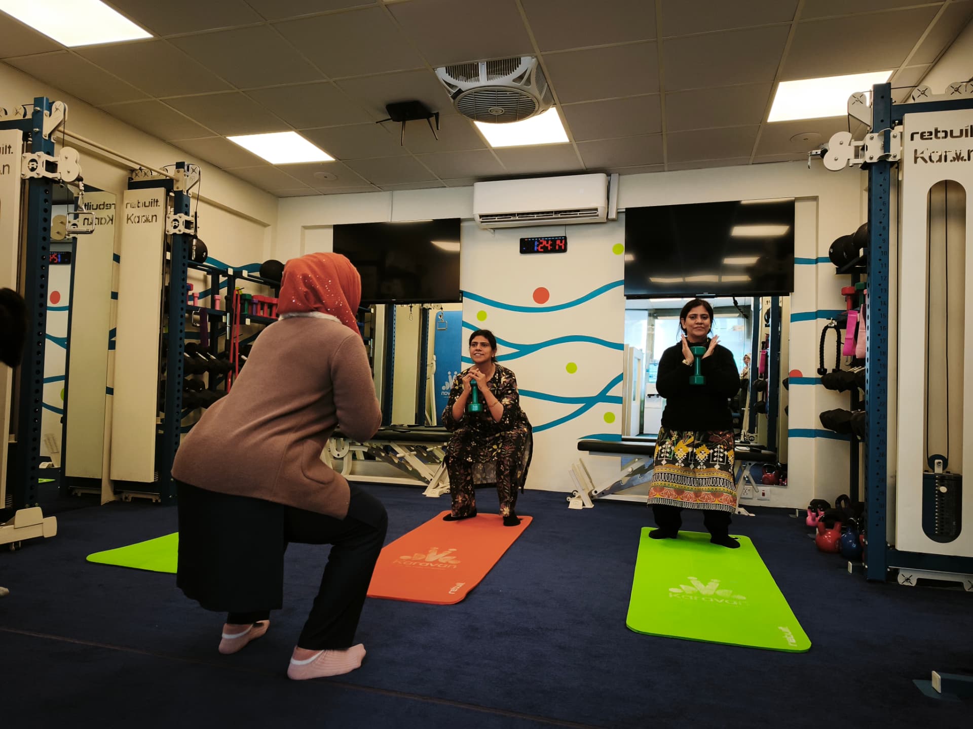 Women practicing squats during a small-group training session